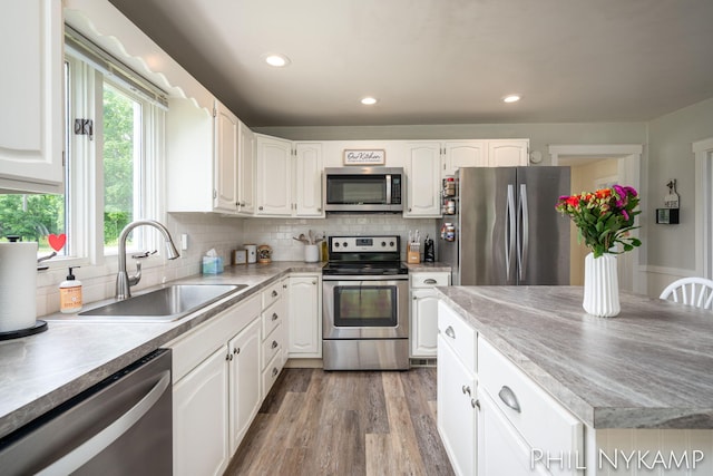 6810 Pierce St, Allendale, MI 49401 - kitchen featuring appliances with stainless steel finishes, a sink, white cabinetry, recessed lighting, and light wood-style flooring