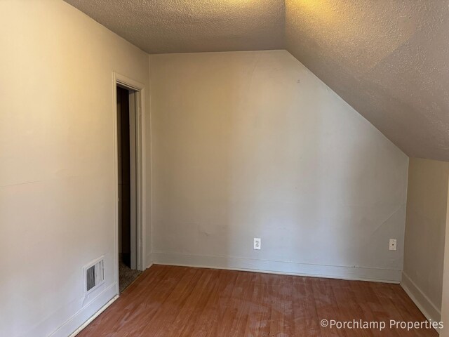 1257 3rd St, Muskegon, MI 49441 - bonus room with wood finished floors, a textured ceiling, lofted ceiling, and baseboards