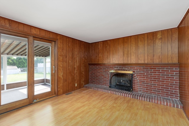 3604 Pall Dr, Warren, MI 48092 - unfurnished living room with light wood-type flooring, a fireplace, and wood walls