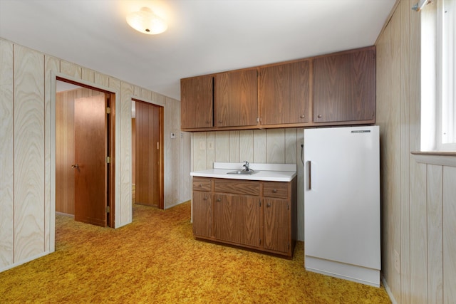 3604 Pall Dr, Warren, MI 48092 - kitchen with light countertops, brown cabinetry, freestanding refrigerator, light colored carpet, and a sink