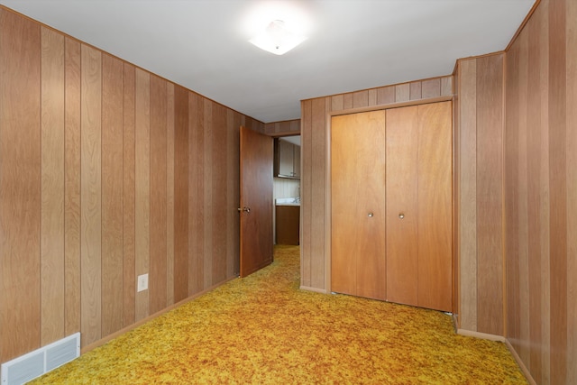 3604 Pall Dr, Warren, MI 48092 - unfurnished bedroom featuring a closet, carpet floors, and wooden walls