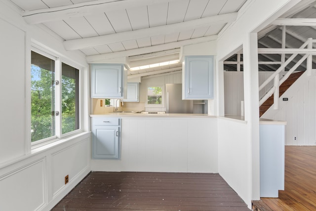 1931 Charlotte Landing Rd, Springport, MI 49284 - kitchen with dark wood finished floors, beamed ceiling, freestanding refrigerator, light countertops, and blue cabinets