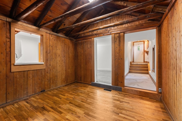 1931 Charlotte Landing Rd, Springport, MI 49284 - empty room with wood-type flooring, wooden walls, wooden ceiling, and stairs