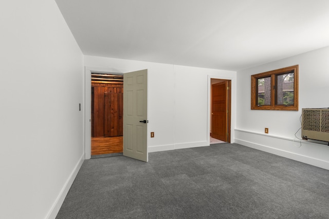1931 Charlotte Landing Rd, Springport, MI 49284 - unfurnished bedroom with dark carpet, baseboards, and heating unit