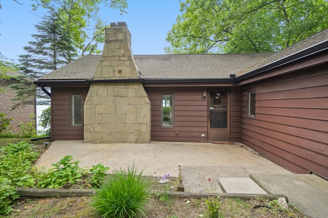 1931 Charlotte Landing Rd, Springport, MI 49284 - back of house with a shingled roof, a patio area, and a chimney