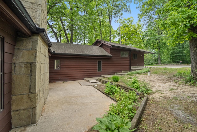 1931 Charlotte Landing Rd, Springport, MI 49284 - view of property exterior featuring a shingled roof and a patio
