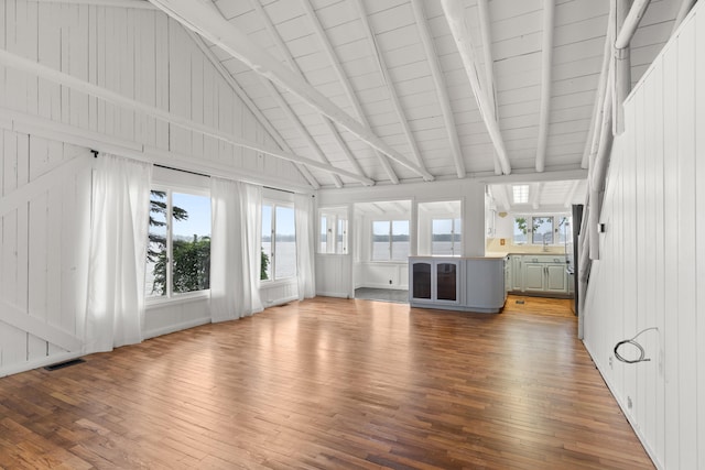1931 Charlotte Landing Rd, Springport, MI 49284 - unfurnished living room with hardwood / wood-style floors, beamed ceiling, and high vaulted ceiling