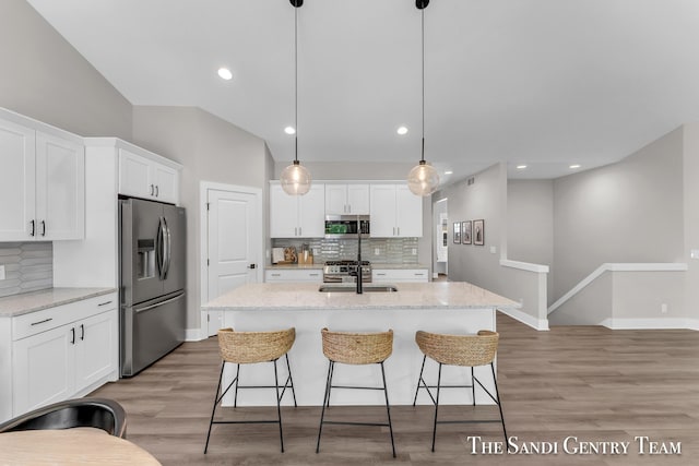 16371 Wickshire Pl, Spring Lake, MI 49456 - kitchen with appliances with stainless steel finishes, decorative backsplash, a sink, white cabinets, and vaulted ceiling