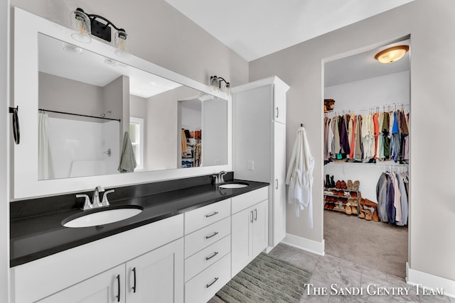 16371 Wickshire Pl, Spring Lake, MI 49456 - full bathroom with double vanity, a spacious closet, a shower with shower curtain, and baseboards