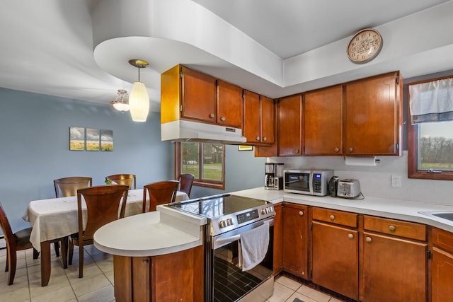13405 Ellis Rd, Conklin, MI 49403 - kitchen with stainless steel appliances, under cabinet range hood, light tile patterned floors, a peninsula, and light countertops