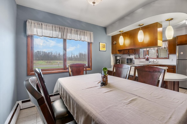 13405 Ellis Rd, Conklin, MI 49403 - dining space with light tile patterned floors, healthy amount of natural light, a baseboard radiator, and baseboards
