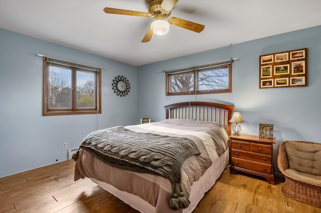 13405 Ellis Rd, Conklin, MI 49403 - bedroom featuring wood finished floors, a ceiling fan, and a baseboard heating unit