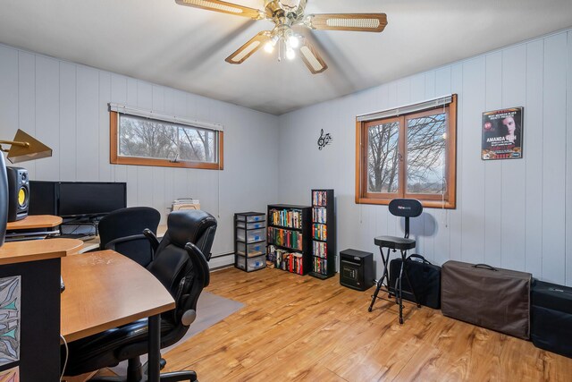 13405 Ellis Rd, Conklin, MI 49403 - home office with light wood-type flooring, a ceiling fan, baseboard heating, and a decorative wall
