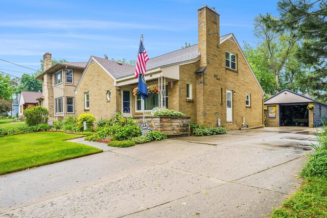 740 Halena St NE, Grand Rapids, MI 49505 - view of front facade with an outdoor structure, a chimney, driveway, and brick siding
