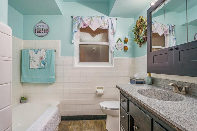 740 Halena St NE, Grand Rapids, MI 49505 - full bathroom with tile walls, toilet, a garden tub, vanity, and wood finished floors