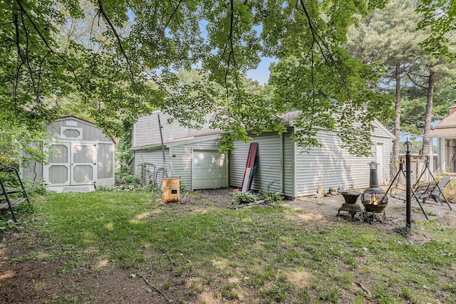 18930 G Dr N, Marshall, MI 49068 - rear view of property featuring an outdoor fire pit, a yard, and a detached garage