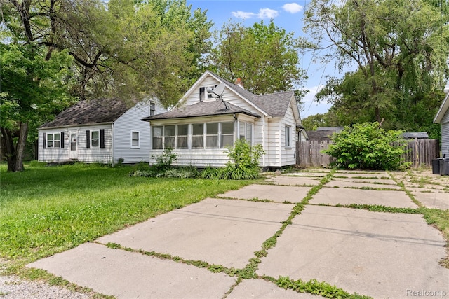 3120 Stratford St, Flint, MI 48504 - view of front of property with roof with shingles, concrete driveway, a sunroom, and a chimney