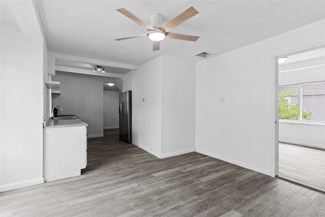 3120 Stratford St, Flint, MI 48504 - unfurnished living room with a sink, light wood-style flooring, a ceiling fan, and baseboards