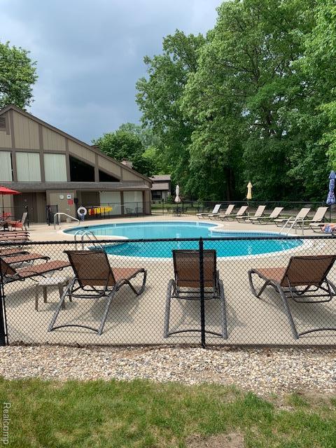 1830 Streamedege Court 27 & 28, Rochester Hills, MI 48309 - community pool with a patio and view of scattered trees