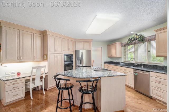 4825 Mirror Lake Dr, West Bloomfield, MI 48323 - kitchen featuring black appliances, a sink, a center island with sink, light brown cabinets, and a kitchen bar