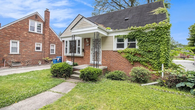 25695 Orchard Dr, Dearborn Heights, MI 48125 - view of front of home featuring brick siding, a front lawn, and a chimney