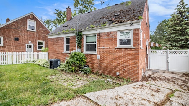 25695 Orchard Dr, Dearborn Heights, MI 48125 - view of property exterior featuring brick siding, a chimney, and a gate