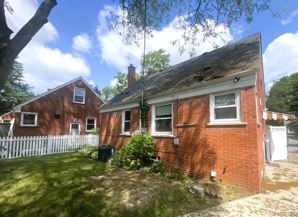 25695 Orchard Dr, Dearborn Heights, MI 48125 - back of house featuring brick siding and a chimney