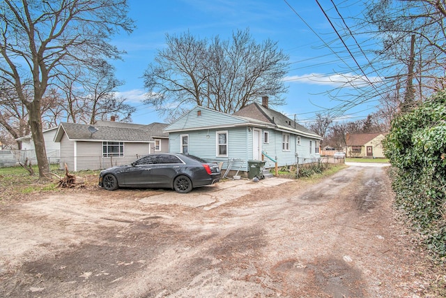 1527 Madison St, Muskegon, MI 49442 - view of home's exterior featuring a chimney and roof with shingles