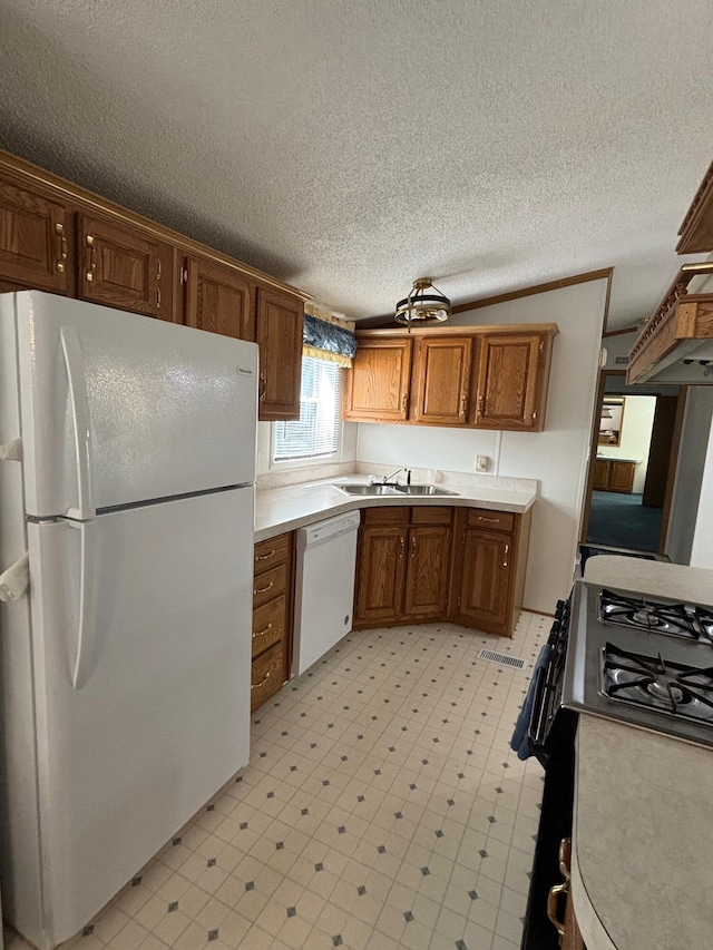 530 N June Dr, Mears, MI 49436 - kitchen featuring white appliances, a sink, brown cabinetry, light floors, and light countertops