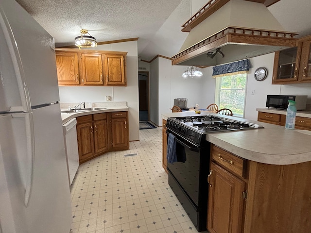 530 N June Dr, Mears, MI 49436 - kitchen featuring black appliances, vaulted ceiling, a sink, light floors, and brown cabinetry