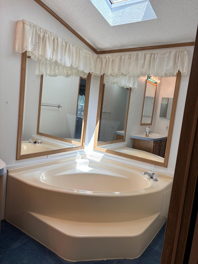 530 N June Dr, Mears, MI 49436 - full bath featuring a skylight, vanity, a textured ceiling, lofted ceiling, and a bath