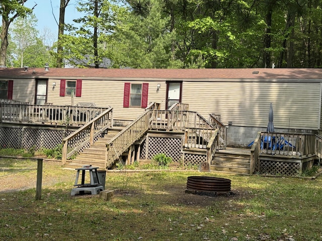530 N June Dr, Mears, MI 49436 - back of house featuring stairs, a wooden deck, and a lawn
