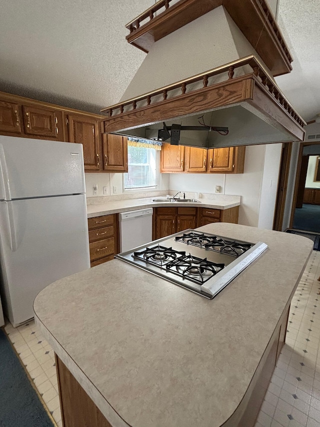 530 N June Dr, Mears, MI 49436 - kitchen featuring white appliances, a textured ceiling, light countertops, a sink, and lofted ceiling
