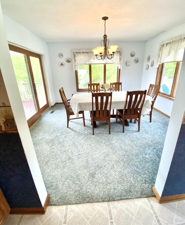 3561 Barber Rd, Hastings, MI 49058 - dining area featuring a chandelier, light colored carpet, and baseboards
