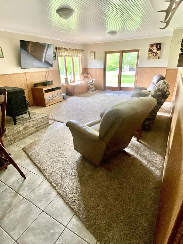 3561 Barber Rd, Hastings, MI 49058 - living area featuring wainscoting, a wood stove, tile patterned floors, and wood walls