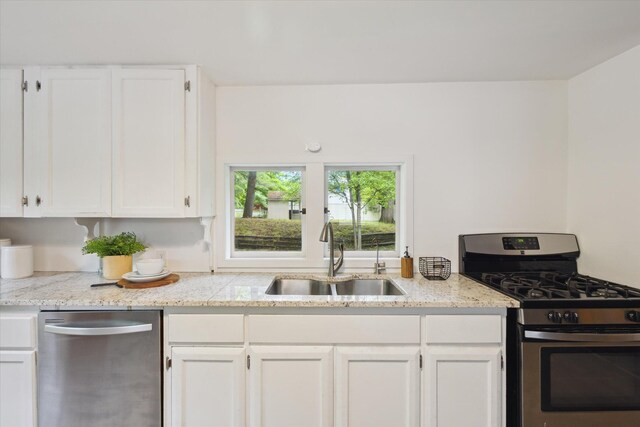6780 Packer Dr NE, Belmont, MI 49306 - kitchen featuring appliances with stainless steel finishes, a sink, white cabinets, and light stone countertops