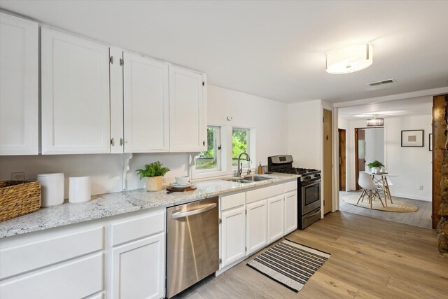 6780 Packer Dr NE, Belmont, MI 49306 - kitchen with appliances with stainless steel finishes, a sink, light wood-type flooring, white cabinets, and light stone counters
