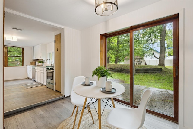 6780 Packer Dr NE, Belmont, MI 49306 - dining area with light wood-style flooring, baseboards, and a chandelier