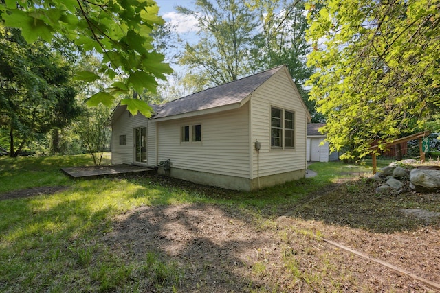 6780 Packer Dr NE, Belmont, MI 49306 - view of side of property featuring a shingled roof, a lawn, and a patio