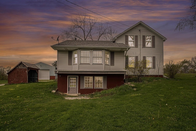66546 Birch Rd, Jones, MI 49061 - back of house featuring a lawn, an outdoor structure, and a detached garage