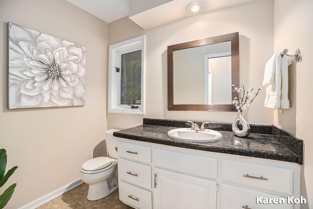 240 Pettis Ave NE, Ada, MI 49301 - bathroom featuring vanity, toilet, tile patterned flooring, and baseboards