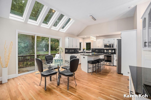 240 Pettis Ave NE, Ada, MI 49301 - dining room with a skylight, light wood-style floors, and high vaulted ceiling