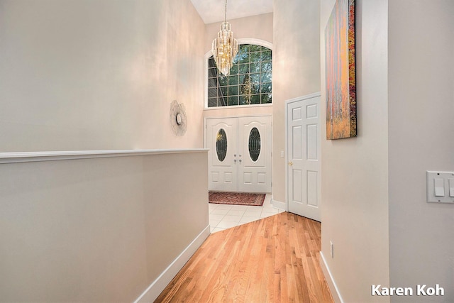 240 Pettis Ave NE, Ada, MI 49301 - entrance foyer with a chandelier, a towering ceiling, wood finished floors, and baseboards
