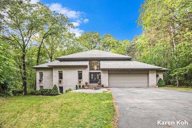 240 Pettis Ave NE, Ada, MI 49301 - view of front of home with asphalt driveway, a front yard, a garage, french doors, and brick siding