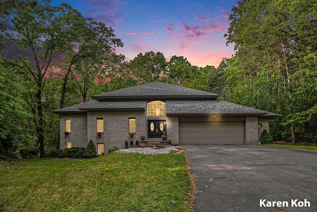240 Pettis Ave NE, Ada, MI 49301 - view of front of home with driveway, a front yard, an attached garage, brick siding, and roof with shingles