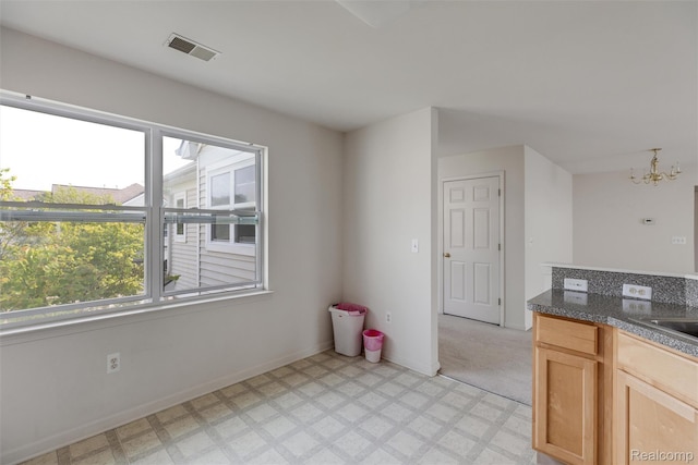612 Riverstone Ln Unit 75, Chelsea, MI 48118 - kitchen featuring plenty of natural light, light flooring, a chandelier, and dark countertops