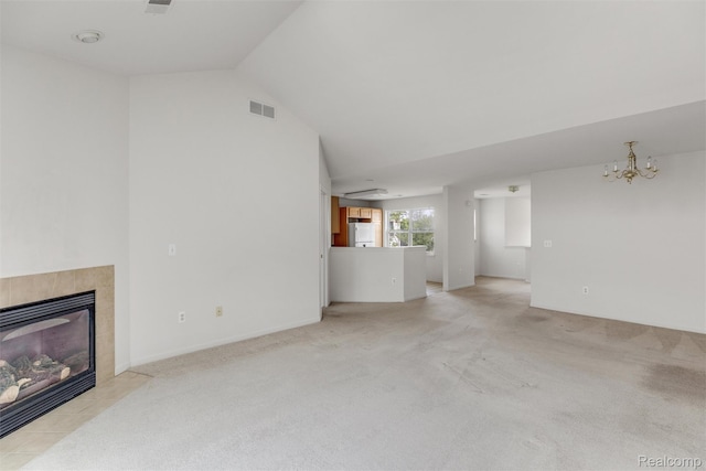 612 Riverstone Ln Unit 75, Chelsea, MI 48118 - unfurnished living room with a chandelier, a tiled fireplace, light carpet, and vaulted ceiling