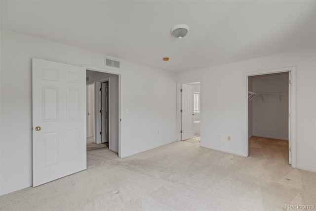 612 Riverstone Ln Unit 75, Chelsea, MI 48118 - unfurnished bedroom with light carpet, a spacious closet, connected bathroom, and baseboards
