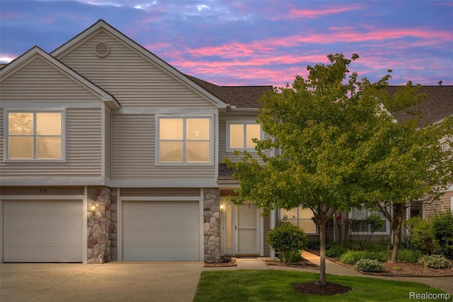 612 Riverstone Ln Unit 75, Chelsea, MI 48118 - townhome / multi-family property featuring driveway, stone siding, an attached garage, and roof with shingles