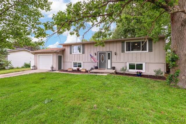 311 Marion St, Clinton, MI 49236 - split foyer home featuring board and batten siding, driveway, a garage, and a front lawn